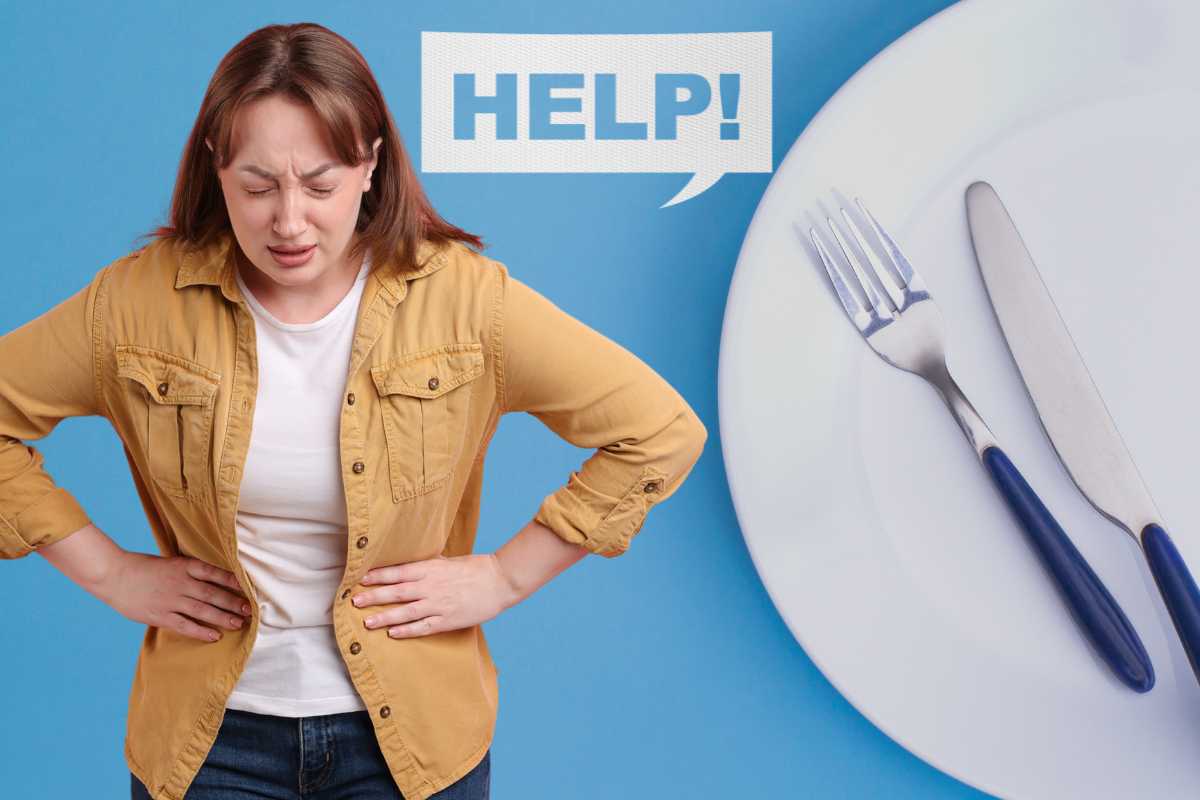 donna si tocca i fianchi e la scritta help affianco a un piatto vuoto