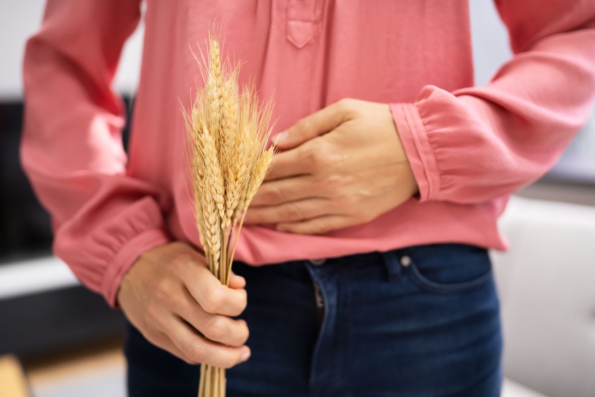 donna che si tocca la pancia e con in mano del grano